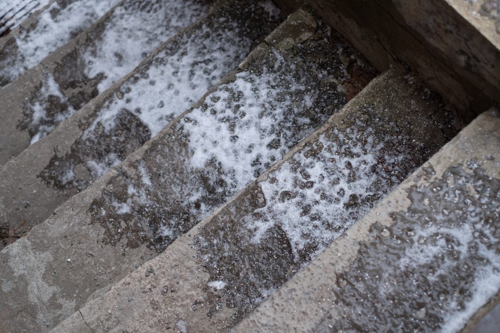 Shown by the flaking edges, exposed aggregate, and crumbling step faces.